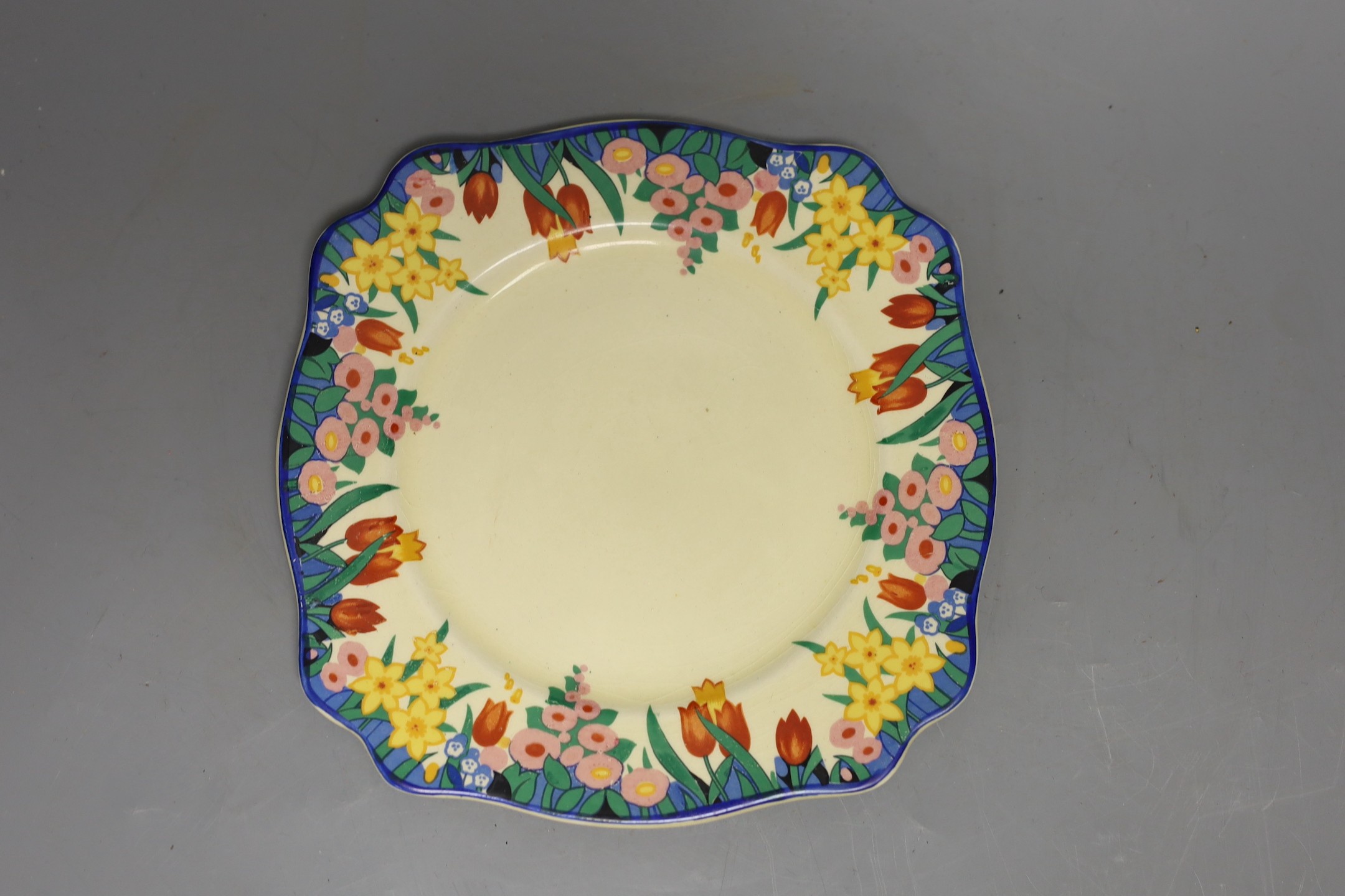 A Clarice Cliff crocus design milk jug and a Bizarre patterned side plate, jug 11.5 cms high